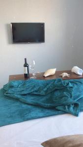 南圣弗朗西斯科Pousada Ohana Dullius的一张木桌,床上放着一瓶葡萄酒