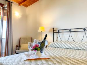 皮特拉利古伊尔卡畔诺旅馆的一间卧室配有一张床,提供一瓶葡萄酒和鲜花
