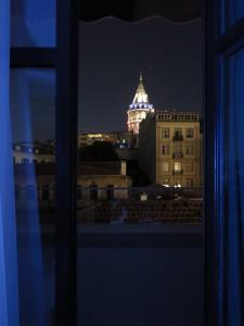 伊斯坦布尔GALATAHAN Hotel Istanbul Karakoy的享有大楼的景色,在晚上设有钟楼