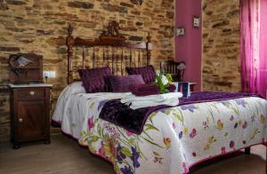 巴雷罗斯鲁米乡村民宿 - 仅限成人的一间卧室配有一张带木制床头板和紫色墙壁的床。