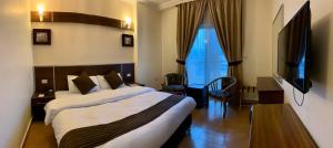 安曼Ream Hotel Amman的酒店客房,配有床和电视
