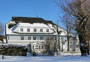 阿伦斯霍普豪斯安特耶酒店的一座白色的大房子,上面有雪