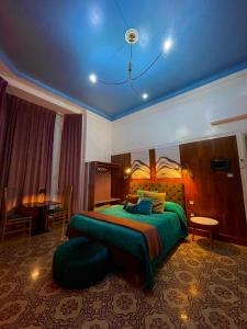 雷焦卡拉布里亚PALAZZO FIACCADORI - Historical Palace的一间卧室设有绿色的床和蓝色的天花板