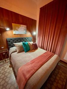 雷焦卡拉布里亚PALAZZO FIACCADORI - Historical Palace的一间卧室配有一张带色彩缤纷枕头的大床