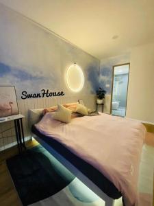 诗巫Premium Swanhouse no.SiX with 3bedrooms Condo的卧室配有一张大床,墙上有标志