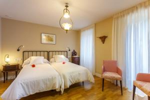 FriolHotel Casa da Galbana的一间卧室配有白色床单和红色鲜花。