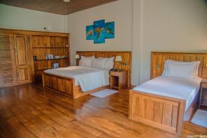 坦加拉Lagoon gate Tangalle Resort的一间卧室设有两张床,铺有木地板