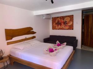萨玛拉Beach Front Bahia的一间卧室,床上放着两朵鲜花