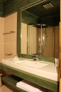 科尔蒂纳丹佩佐农场猎人之家旅馆的浴室设有白色水槽和镜子