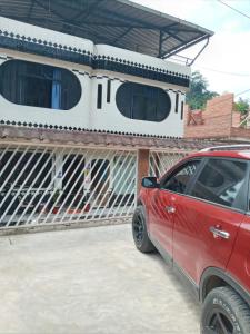 廷戈玛丽亚HOSPEDAJE EL CANTARO的停在房子前面的红色汽车