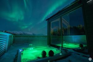 阿尔塔Flatmoen Natur Lodge的客房享有北灯的景致,配有热水浴池。