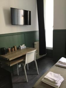 巴黎Hotel Geoffroy Marie Opéra的一间带木桌和椅子的用餐室