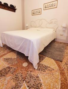 比萨Relais Pacinotti Rooms的一间卧室配有一张床铺,床上铺有白色毯子