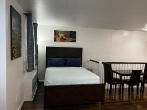 布鲁克林法克博公寓的卧室配有一张床和一张桌子及椅子