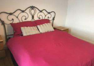 凯特林4 Bedroom House For Corporate Stays in Kettering的一间卧室配有红色的床和两个枕头