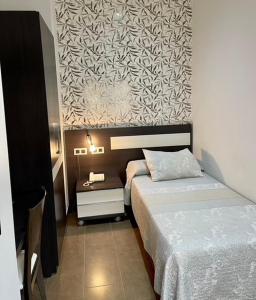 代米耶尔戴米尔酒店的一间卧室设有两张床,墙上贴有壁纸。