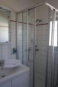 沃尔芬比特尔Hotel Gästehaus Linden的带淋浴和盥洗盆的浴室
