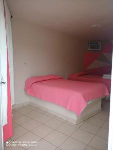 特科卢特拉Villa kosniin的一间卧室配有两张带粉红色毯子的床
