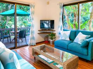石垣岛夏至南风度假屋的客厅配有蓝色的沙发和电视