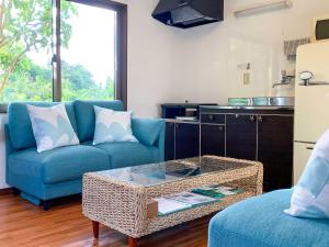 石垣岛夏至南风度假屋的客厅配有蓝色的沙发和桌子