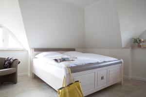 富伦多夫Ferienhaus Seeadler 24的卧室内的一张白色床,带有黄色袋子