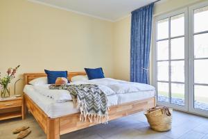 富伦多夫Ferienhaus Graukranich 41的一间卧室配有一张带蓝色窗帘的木床