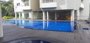 KottawaLuxe Highway Residencies的大楼前的大型蓝色游泳池