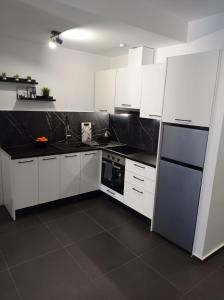 帕特雷NY Central 1的厨房配有白色橱柜和黑色台面