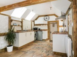 纽基Barn Acre Cottage的厨房配有白色橱柜和拱形天花板