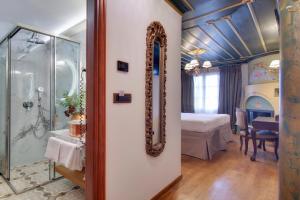 约阿尼纳ARCHONTARIKI Historic Boutique Hotel的一间带镜子的浴室和一间带床的卧室