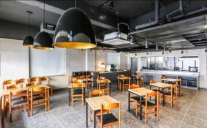 济州市Jeju Renaissance Hotel的一间带木桌椅的餐厅和一间厨房