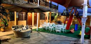 卡拉瓜塔图巴迎宾天堂酒店的一个带桌椅的庭院和一个游乐场