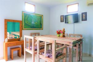 AbeansemalKarauci Homestay的一间带桌椅和电视的用餐室