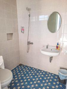 巴图Rosemary Homestay的一间带卫生间、水槽和镜子的浴室