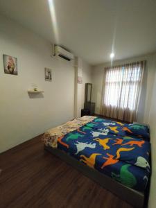 马六甲JOKA-JOKA GUESTHOUSE的一间卧室配有一张带彩色毯子的床