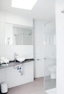 阿利坎特圣雷莫酒店的白色的浴室设有水槽和淋浴。