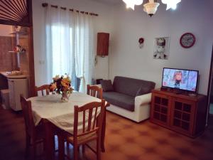 维拉诺瓦Villetta Paola marina di Ostuni的客厅配有桌子、沙发和电视