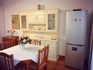 维拉诺瓦Villetta Paola marina di Ostuni的厨房配有桌子和白色冰箱。