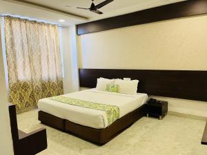 海得拉巴Hotel Elite By Signature Group的一间卧室设有一张大床和一个窗户。