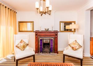 努沃勒埃利耶Tudor Barn - Little England Cottages的客厅配有两把椅子和壁炉