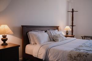 努沃勒埃利耶Tudor Barn - Little England Cottages的一间卧室配有一张带枕头的床和两盏灯。