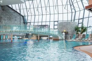 朗根费尔德四星级水族圆顶高级酒店的一座带玻璃天花板的建筑中的游泳池