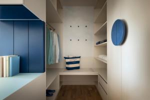 扎达尔法肯斯特尼狄亚多拉家庭酒店的步入式衣柜,内配蓝色和白色的橱柜