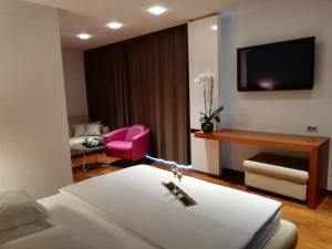 默主歌耶赢酒店的酒店客房,配有一张床和一张粉红色的椅子