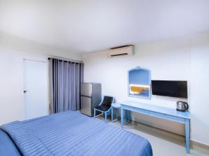 巴吞他尼Chateau Hotel & Apartments的配有一张床和一张书桌的酒店客房