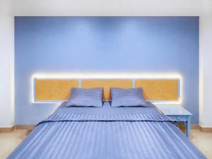 巴吞他尼Chateau Hotel & Apartments的蓝色的卧室,配有一张蓝色墙壁的床