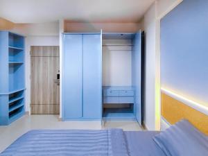 巴吞他尼Chateau Hotel & Apartments的一间卧室配有一张蓝色的床和一个衣柜