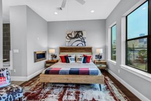 休斯顿Modern, Houston Inspired House with Best Views of Downtown! - Less than 1 mile to Eado Midtown Bars home的一间卧室设有一张床和两个窗户。