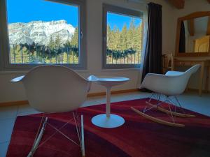 福尔加里亚Hotel Elbele Garnì的带两扇窗户的客房内的两把椅子和一张桌子