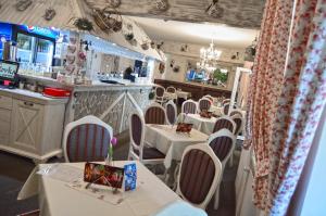 帕蒂赞斯克Penzion Batovka u Hoffera的一间设有白色桌椅的餐厅和一间酒吧